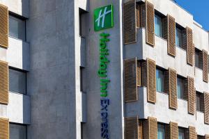 波尔图Holiday Inn Express Porto City Centre, an IHG Hotel的建筑的一侧有绿色标志