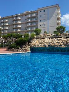 布拉内斯Apartamento MARINA PLAYA, primera linea de mar的大楼前的大型游泳池