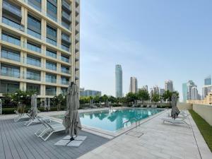 迪拜Amazing apartment next to Dubai Mall 160BR-2的一座大楼内的游泳池,配有椅子和遮阳伞