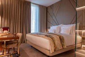 里斯本Wine & Books Lisboa Hotel的酒店客房配有一张床、一张书桌和一张四柱床。