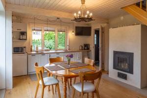 库雷萨雷Cosy Family Guesthouse with Sauna and Garden的厨房以及带木桌和椅子的用餐室。