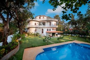 果阿旧城SaffronStays Amarah Pet-friendly Luxury Villa-Assagao, North Goa的享有带游泳池的大厦外部景色