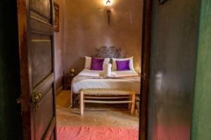 马拉喀什Riad en Exlusivité à 5min de la place jamaa el fna的一间卧室配有一张带紫色枕头的床