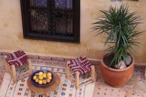 马拉喀什Riad en Exlusivité à 5min de la place jamaa el fna的一张桌子,两把椅子和一碗水果