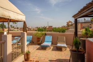 马拉喀什Riad en Exlusivité à 5min de la place jamaa el fna的阳台的天井配有2把蓝色椅子