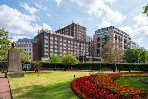伦敦丹乌比斯摄政公园酒店的建筑前有鲜花的公园