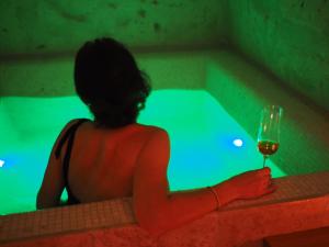 马泰拉Dimore dei Mercanti的坐在浴缸里的女人,喝一杯葡萄酒