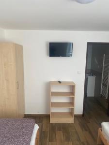 Mariánské RadčicePenzion Norden的卧室配有一张床,墙上配有电视。