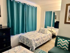 HoquiamLeah's Homestay in Hoquiam的一间卧室设有两张床和蓝色窗帘
