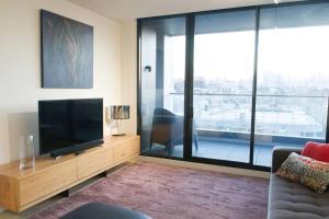 墨尔本Modern Spacious 2BD2Bath - Stunning City Views!的一间带电视和大窗户的客厅