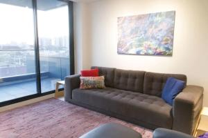 墨尔本Modern Spacious 2BD2Bath - Stunning City Views!的带沙发和绘画的客厅