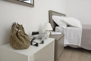 托里德欧索Baia Dell'Orso的一间卧室配有一张床、电话和钱包