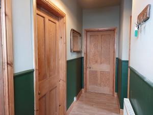 因纳利森Cosy flat in Innerleithen的走廊设有木门和绿色的墙壁