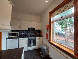 因纳利森Cosy flat in Innerleithen的一间厨房,配有白色家电和大窗户