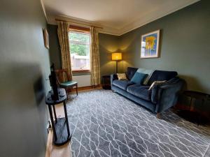 因纳利森Cosy flat in Innerleithen的客厅设有蓝色的沙发和窗户。