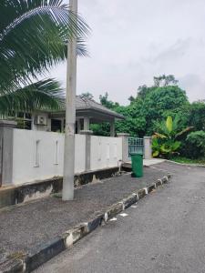 居林Creatills luxury homestay Kulim & hi-tech的一座房子前面的棕榈树,有垃圾桶