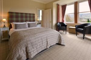 皮特洛赫里The Poplars Guest House的一间卧室设有一张大床、椅子和窗户。
