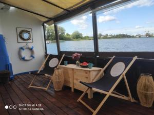 帕克Houseboat GDY-50, dom na wodzie z sauną i jacuzzi的两把椅子和一张桌子,在船的背面