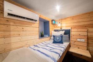 帕克Houseboat GDY-50, dom na wodzie z sauną i jacuzzi的一间卧室设有木墙和一张带蓝色枕头的床。