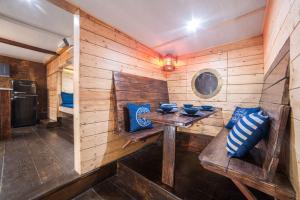 帕克Houseboat GDY-50, dom na wodzie z sauną i jacuzzi的木制客房配有桌子和蓝色枕头