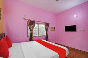 加尔各答Hotel Salt Lake Palace Kolkata Sector II Near Dum Dum Park - Fully Air Conditioned and Spacious Room - Couple Friendly的粉红色的卧室配有床和电视