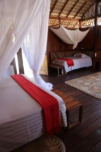 阿廷斯Vila Guará的一间卧室设有两张床和天篷