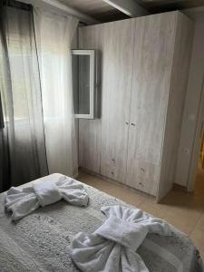 Kynopiástaig&z cottage的一间卧室配有一张带白色床单的床和橱柜。