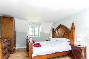奇平卡姆登Robin Cottage的一间卧室配有一张大床和木制床头板