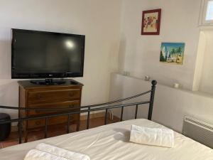普罗旺斯艾克斯Le Cardinale - Un Voyage en Provence的一间卧室设有平面电视和一张床。