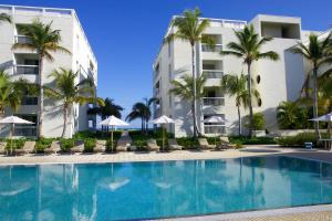 格雷斯湾Le Vele Resort的棕榈树酒店前的游泳池