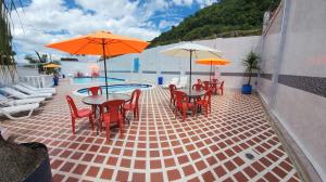 巴尔博萨帝王酒店的一个带桌椅、遮阳伞和游泳池的庭院