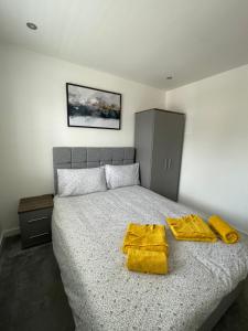 谢菲尔德Stylish and Modern 2BR Apartment with Parking的一间卧室配有一张带两张黄色毛巾的床