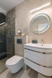 下厄尔什Club Panorama Lake View Apartment的一间带卫生间、水槽和镜子的浴室
