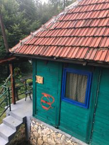 ProkupljeBeli Kamen etno selo的一座无门的绿色房子