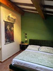 雷焦艾米利亚Borgogna 14的卧室配有一张床,墙上挂有绘画作品