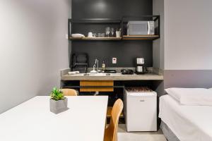 圣保罗Studio 2 Pinheiros by Oba的一个带水槽和桌子的小厨房
