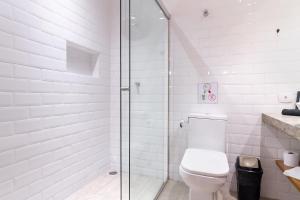 圣保罗Studio 2 Pinheiros by Oba的白色的浴室设有卫生间和玻璃淋浴间。