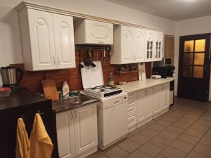 杜什尼基-兹德鲁伊Pokoje, kwatery prywatne przy stoku w Zieleńcu的厨房配有白色橱柜、炉灶和水槽。