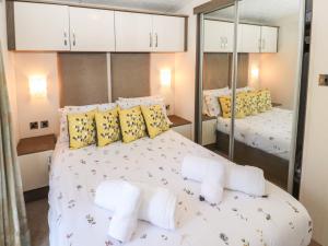 康福斯41, Grandma's Cottage的卧室配有一张带黄色枕头的大型白色床。