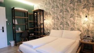 托尔博莱艾伯塔别墅酒店的卧室配有白色的墙壁床
