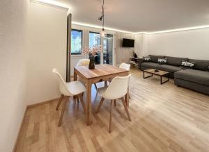 格林德尔瓦尔德Chalet Ribi的客厅配有木桌和白色椅子