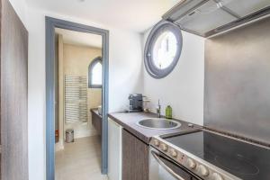 马赛Small private house 4P1BR - Marseille 8th的厨房配有水槽和墙上的时钟