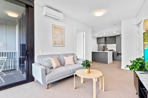 悉尼New Amazing Park City high level APT的客厅配有沙发和桌子