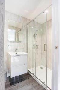 布兰德福德福鲁姆The Secret, Stylish & Spacious En Suite in Blandford Forum, Dorset的带淋浴、盥洗盆和浴缸的浴室