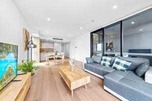 悉尼Adorable 2B Apt near Macquarie Uni的客厅配有沙发和桌子