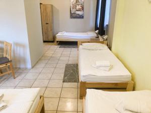 格利维采Hotel Ava的客房设有三张床,铺有瓷砖地板。