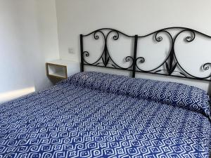 奇亚Casa Chia a 5 minuti dal mare - Su Giudeu Tuerredda的一间卧室配有一张带蓝色和白色床单的床。