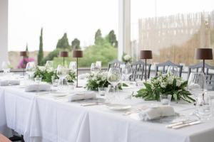 卡普里卡纳斯塔酒店的一组桌子,上面有白色的桌布和鲜花