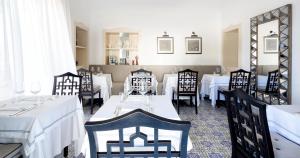 卡普里卡纳斯塔酒店的用餐室配有白色桌子和黑色椅子