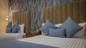 瓦哈卡市ArcoSodi Hotel Boutique的酒店客房 - 带两张带蓝色枕头的床